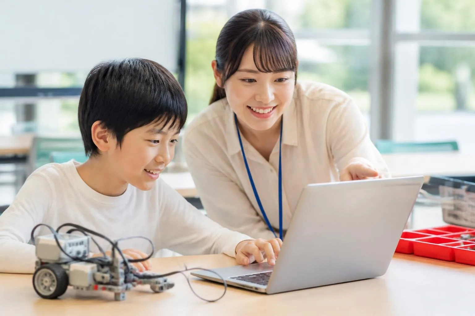 先生が男の子にプログラミングを教えている